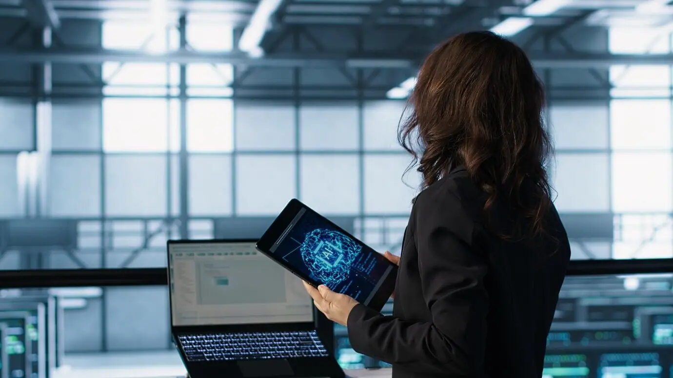 Un técnico en un centro de datos utiliza tecnología de IA en una tableta.